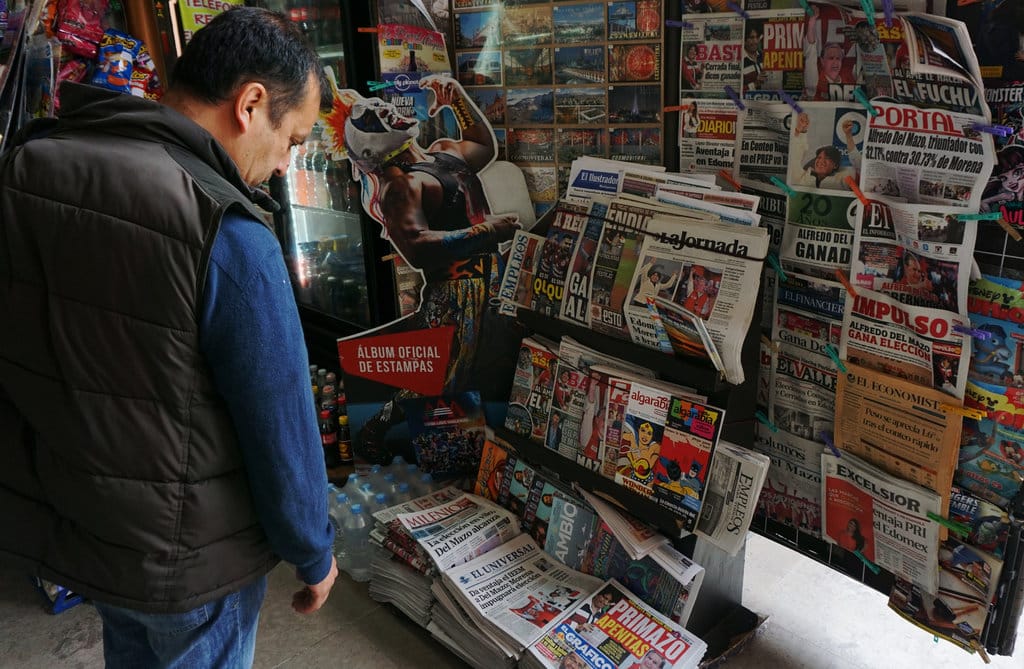 Mexican Man Looking At Newspapers