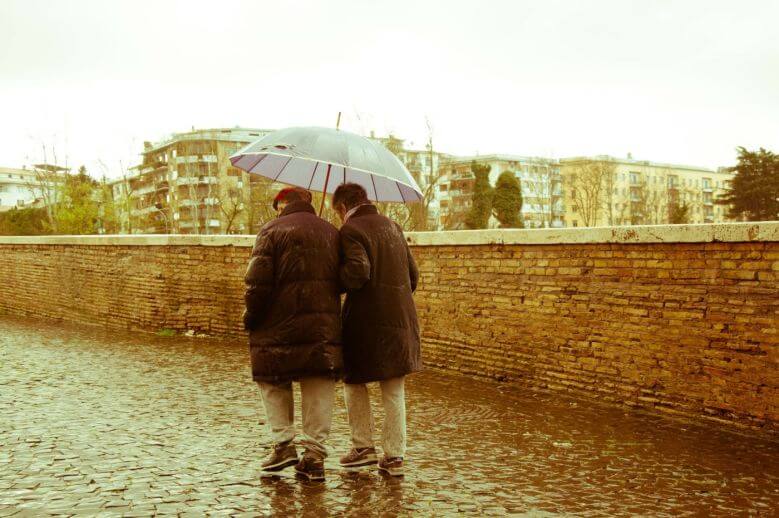Older Couple Walking In The Rain