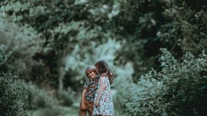 Older Sister Kissing Younger Brother On Cheek